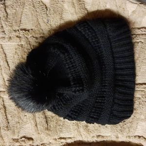 Beanie with detachable fur ball.
